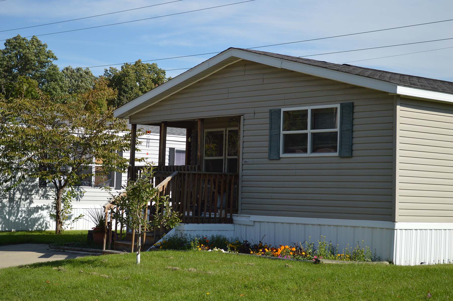 Manufactured home with porch and landscaped lot