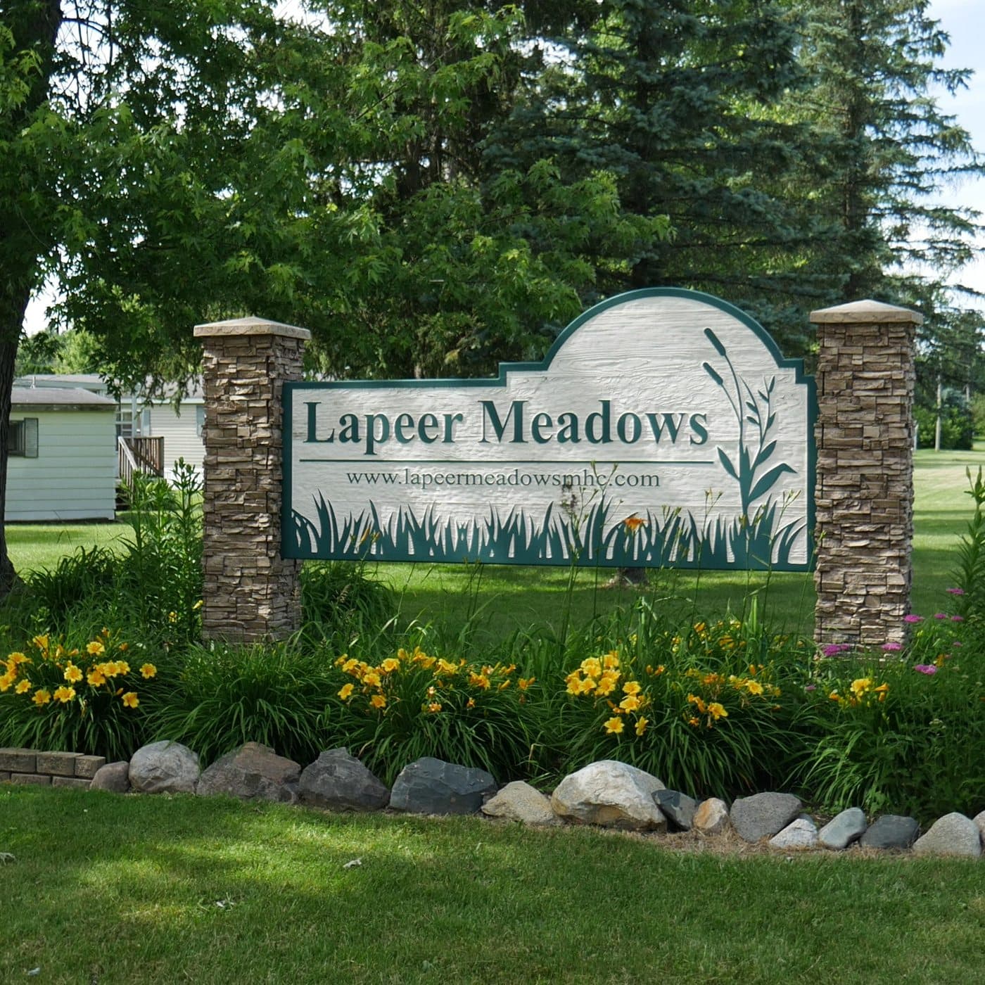 Lapeer Meadows entrance sign with landscaped flower beds